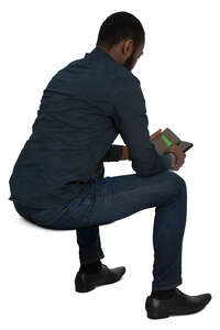 cut out black man sitting and checking his phone