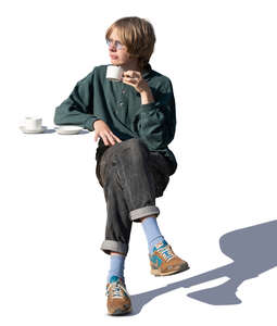 young man sitting in a cafe and drinking coffee