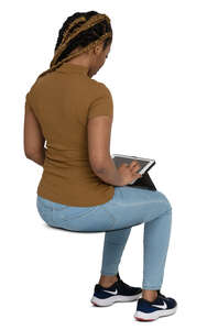 cut out black woman sitting and looking smth at her ipad