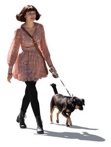 cut out young backlit woman walking a dog