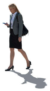 cut out backlit businesswoman with a phone in her hand walking