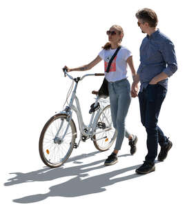cut out backlit couple with a bicycle walking hand in hand