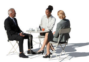 three cut out businesspeople sitting in a cafe and talking