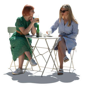 two cut out backlit young women sitting in a cafe and talking