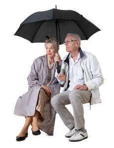 cut out elderly couple sitting together under an umbrella