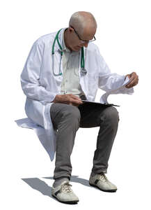 cut out older male doctor sitting and reading some papers