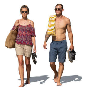 man and woman walking barefoot on the beach