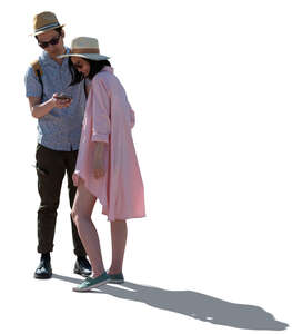 cut out backlit asian couple standing and looking at their smartphone