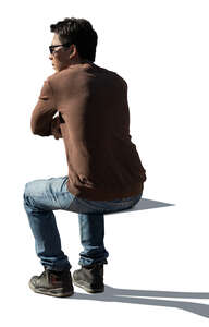 cut out backlit man sitting and leaning on a  table
