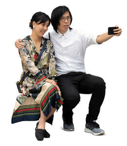 cut out asian man and woman sitting and taking a selfie