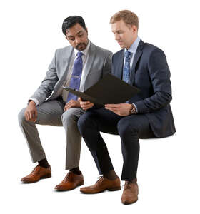 two cut out businessmen sitting and reading some papers