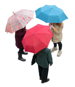 three cut out women with umbrellas standing seen from above
