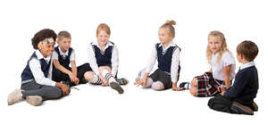 six cut out schoolchildren sitting on the ground in a circle