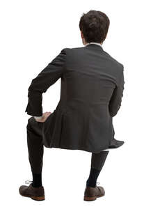 cut out man in a black suit sitting seen from behind