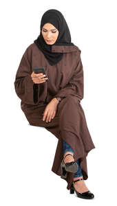 cut out muslim woman in a brown abaya sitting