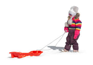 cut out little girl pulling a sledge in the snow