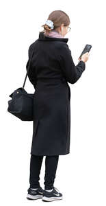 cut out young woman in a black overcoat standing