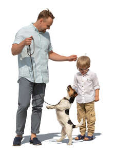 cut out father and son standing and playing with a dog