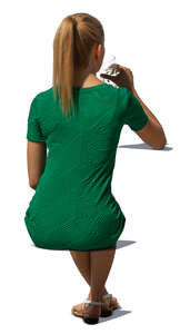 cut out woman in a green dress sitting and drinking water