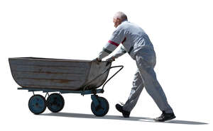 cut out older man pushing a large wheelbarrow