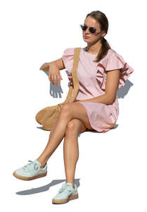 cut out woman in a pink summer dress sitting