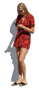 cut out young woman in a red jumpsuit leaning against the wall and texting