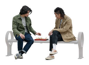 two cut out asian men sitting and playing chess in the park