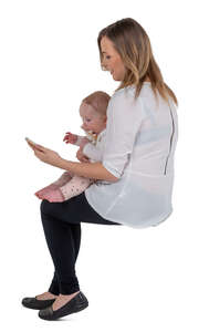 cut out woman holding a baby sitting and making a phone call