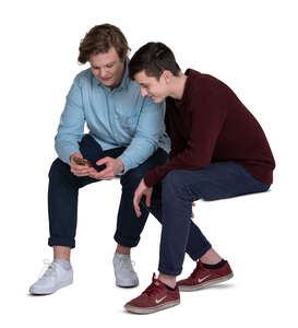 two cut out teenage boys sitting