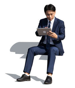 cut out asian  businessman sitting and working with tablet