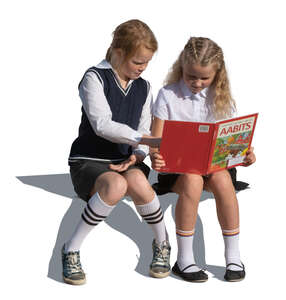 two cut out girls sitting and reading a book