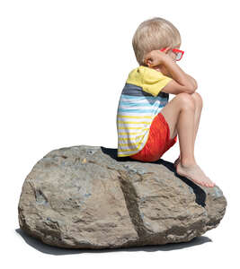 cut out little boy sitting on a big rock