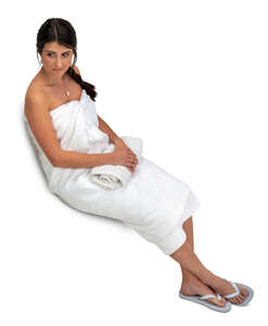 cut out woman in a white sauna towel sitting seen from above