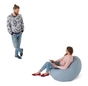 cut out woman sitting in a bean bag talking to a man standing by