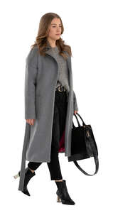 cut out woman in a grey overcoat walking