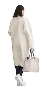 cut out woman in a white overcoat walking