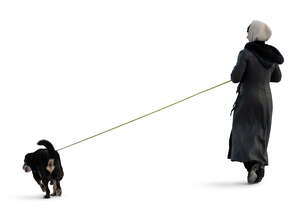 cut out woman in a winter overcoat walking a dog