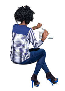 cut out black woman sitting at a table and drinking water