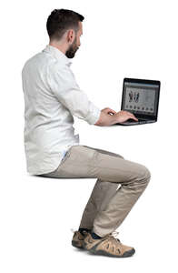 cut out man sitting at a table and working with laptop