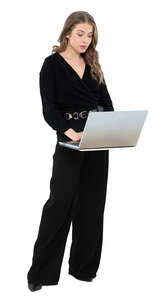 cut out woman in a black costume standing by a desk and working with a laptop