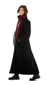 cut out young woman in a long black overcoat walking