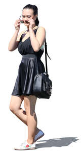 young asian woman in a black summer dress walking