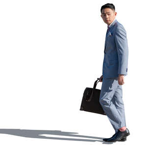 asian man in a pale blue suit walking