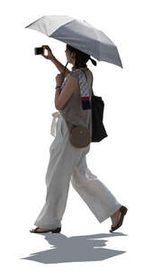 backlit woman with parasol walking