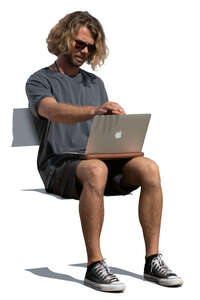 man sitting with a laptop on his knees