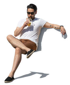 cut out asian man sitting and drinking juice