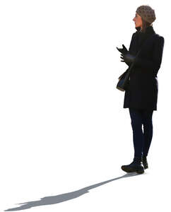 backlit woman in a black autumn jacket standing