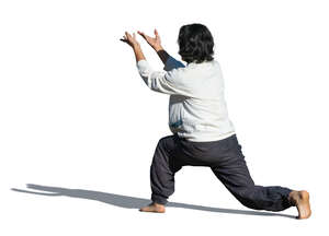 cut out man doing tai chi exercises outside