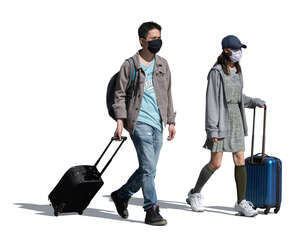 cut out asian man and woman with trolley bags and wearing face masks walking