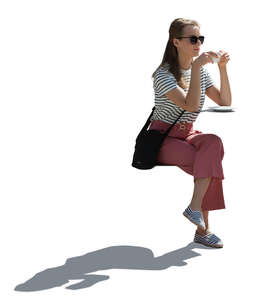 cut out woman sitting outside at a table and drinking coffee